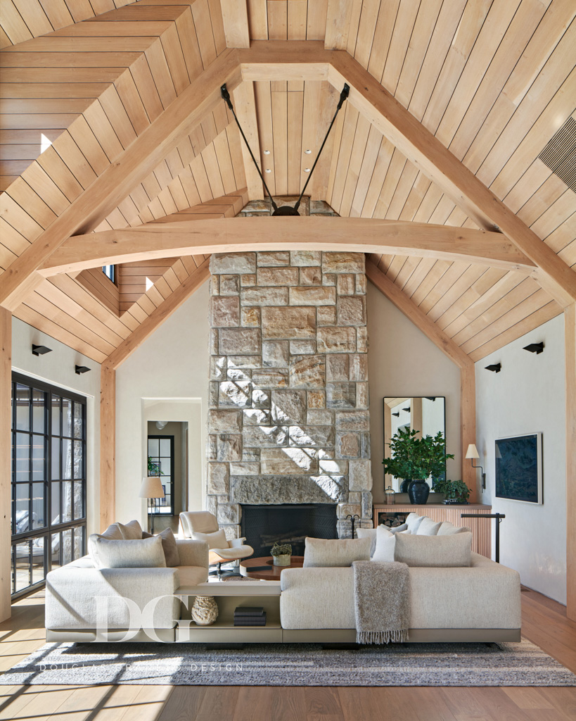 Serene living room with wood paneled vaulted ceiling, stone clad fireplace, and Minotti DDC sectional
